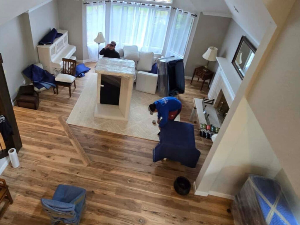 movers wrapping furniture in a living room